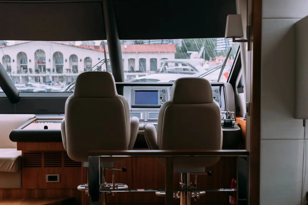 Yacht cockpit with leather helm seats and marina views