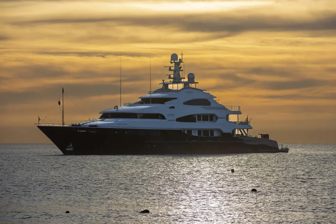 Luxury motor yacht cruising at sunset off the coast