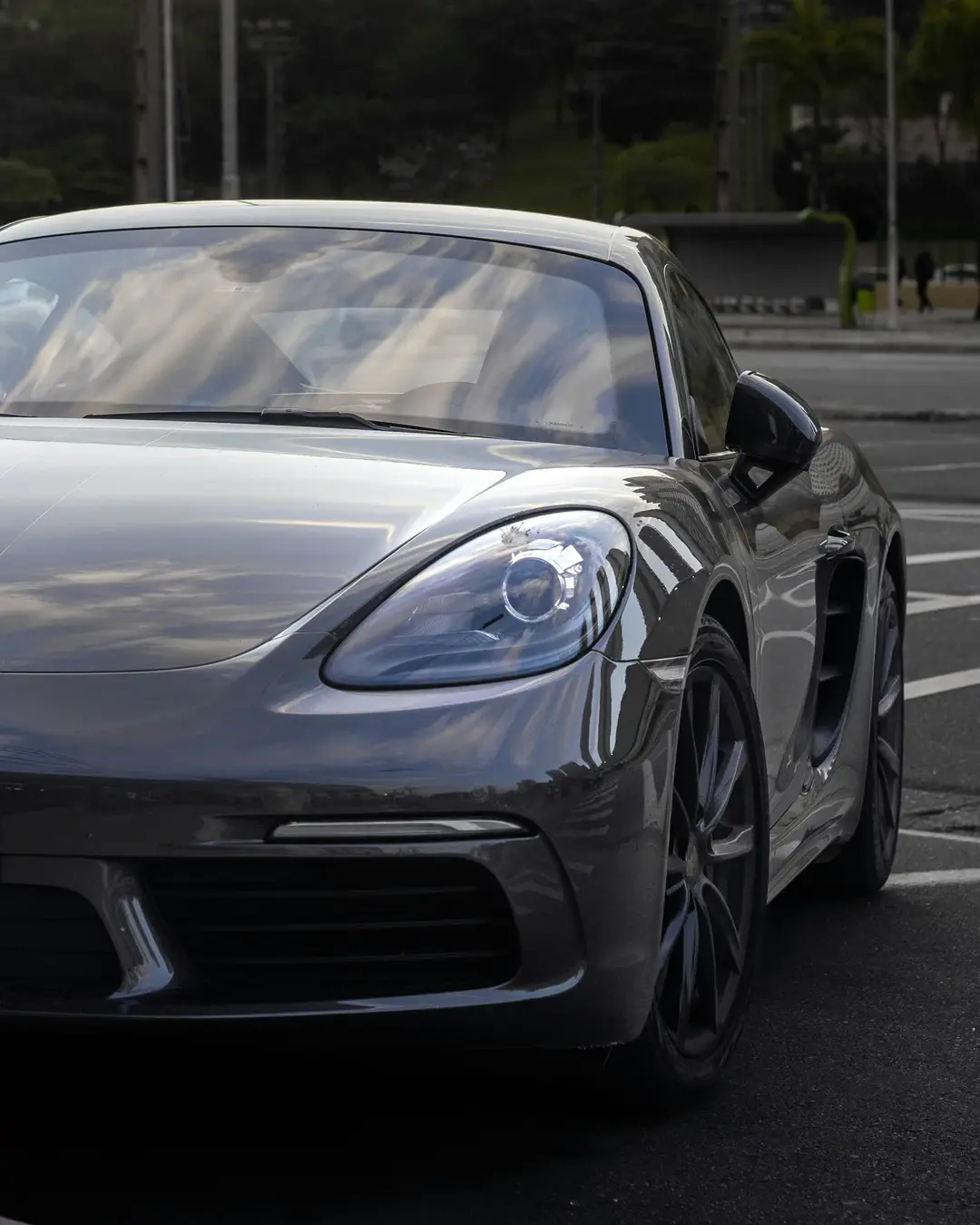 Silver luxury sports car parked on a clean urban street at dusk