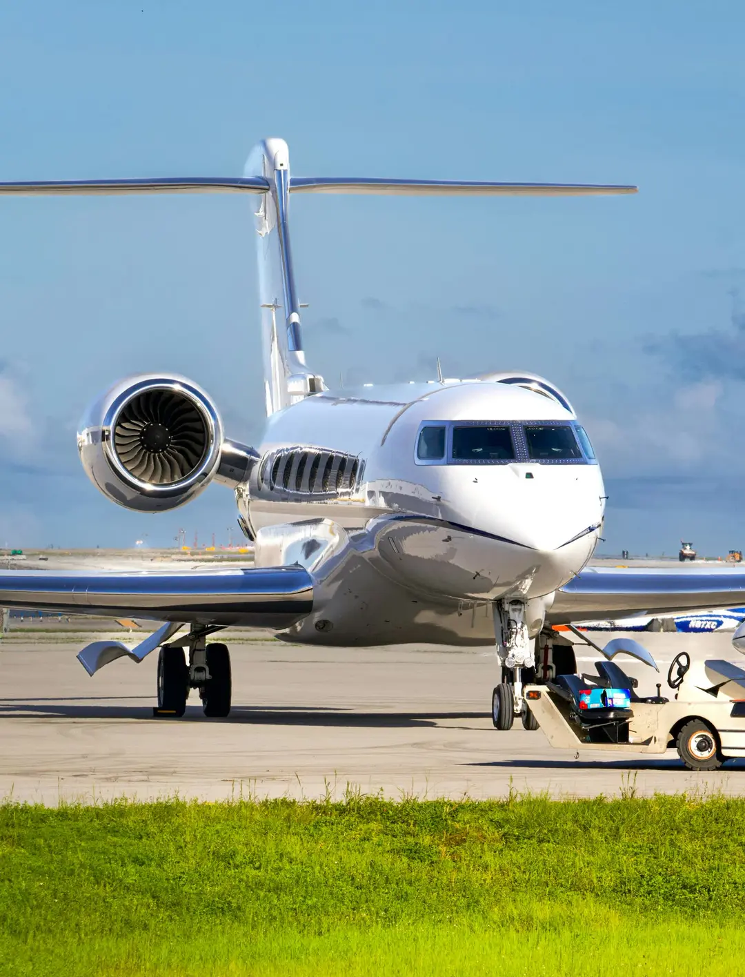 Sleek private jet on the tarmac with a ground tow tug